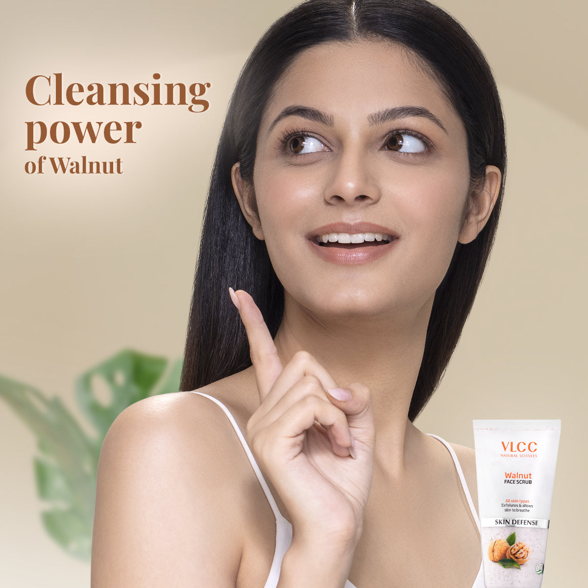 Woman pointing to her face with a VLCC skincare product on a beige background